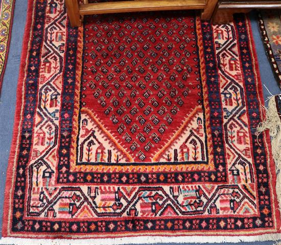 An Arrak red ground runner, 13ft 5in by 3ft 4in.